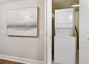 Thumbnail 18 of 27 - A white fridge in a room with a painting on the wall.