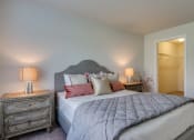 Thumbnail 19 of 26 - Apartments For Rent In Coeur d'Alene, ID - Rockwood Lodge - Bedroom With Carpeted Flooring, Large Bed, Wooden Nightstands With Lamps, And Spacious Closet.