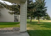 Thumbnail 24 of 26 - Coeur d'Alene, ID, Apartments - Rockwood Lodge - Private Terrace With View Of Large Open Grass Space And Trees.