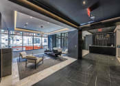 Thumbnail 13 of 31 - Lobby of 3thirty3 New Rochelle NY high-rise, with fireplace, marble floors, modern furniture, floor-to-ceiling windows with street view, and concierge desk.