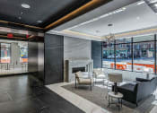 Thumbnail 12 of 31 - Lobby of 3thirty3 New Rochelle NY high-rise. Features fireplace, marble floors, modern seating, and floor-to-ceiling windows with street view.