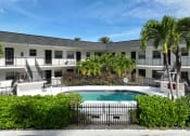 Thumbnail 3 of 12 - a large pool in front of a hotel with palm trees