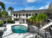 Thumbnail 2 of 12 - a house with a swimming pool and a building with palm trees