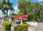 Thumbnail 7 of 8 - A red sign with white lettering on a building reads "1209 Gotee Dr Apartments".