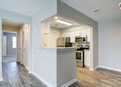 Thumbnail 4 of 19 - Rutland Place Apartments kitchen with black appliances, ample cabinet space, and hardwood-style flooring, pet-friendly apartments in Macon, GA