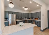 Thumbnail 10 of 22 - Resident clubhouse kitchen with modern cabinetry and gathering space at Sage 5430 apartments in Norcross, GA.