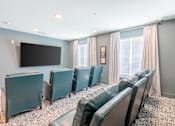 Thumbnail 16 of 22 - Community theater room with reclining chairs for resident movie nights at Sage 5430 near Buford Highway.