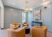Thumbnail 2 of 18 - A living room with a grey wall and a painting hanging on it.