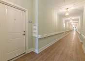 Thumbnail 22 of 22 - Bright interior hallway with elevator access and modern finishes inside Sage 5430 apartments in Norcross, GA.