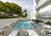 Thumbnail 18 of 29 - Apartments Santa Monica, CA - San Vicente Tower - Swimming Pool with Lounge Chairs and Landscaping