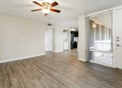 Thumbnail 7 of 18 - Tempe, AZ Apartments – Sentry Tempe – an empty living room with a ceiling fan and hardwood floors