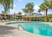 Thumbnail 2 of 18 - Pet-Friendly Apartments in Tempe – Sentry Tempe – a swimming pool in front of a community buildings