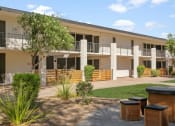 Thumbnail 18 of 18 - Apartments in Tempe, AZ for Rent – Sentry Tempe – an outside view of a building with a garden and benches