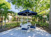 Thumbnail 9 of 19 - a patio with a table and chairs and an umbrella