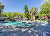 Thumbnail 11 of 19 - a pool with lounge chairs and trees in the background