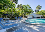 Thumbnail 10 of 19 - a pool with lounge chairs and a building in the background