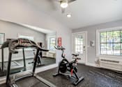 Thumbnail 13 of 19 - a home gym with a treadmill and exercise bike