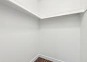 Thumbnail 29 of 46 - A white wall with a corner of a room.