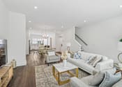 Thumbnail 5 of 39 - A modern living room with a white couch and a coffee table.