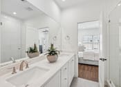 Thumbnail 17 of 39 - A bathroom with a white sink and a mirror.