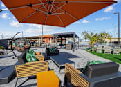 Thumbnail 9 of 25 - A patio with orange umbrellas and wooden chairs.