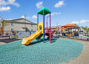 Thumbnail 7 of 25 - A playground with a yellow slide and a blue and green top.