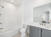 Thumbnail 16 of 39 - A white bathroom with a toilet, sink, and bathtub.