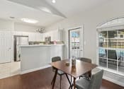 Thumbnail 19 of 19 - Affordable Apartments in Austin, TX for Rent- Huntington Meadows-  A clubhouse kitchen with a table and chairs in front of a window.