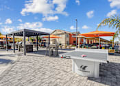 Thumbnail 6 of 25 - A white table tennis table with the brand name "Camilleau" on it is placed on a patio.