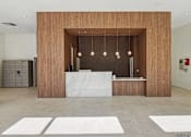 Thumbnail 21 of 27 - 1- & 2-Bedroom Apartments for Rent in Miami, FL – Riverview One Apartments – A reception area with a white counter and a wooden wall.