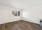 Thumbnail 25 of 46 - A room with a wooden floor and a door leading to a balcony.