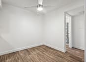 Thumbnail 24 of 46 - A room with a ceiling fan and wooden flooring.