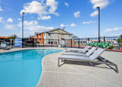 Thumbnail 1 of 25 - A pool with a sun lounger and a building in the background.