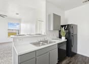 Thumbnail 13 of 19 - Pet-Friendly Apartments in Austin, TX – Huntington Meadows – A kitchen with a black refrigerator and grey cabinets