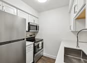 Thumbnail 19 of 46 - A modern kitchen with stainless steel appliances and white cabinets.