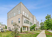 Thumbnail 31 of 39 - A modern building with a grey facade and large windows.
