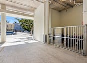 Thumbnail 24 of 27 - Apartments for Rent in Riverview Miami, FL– Riverview One Apartments -   A parking garage with a gate and a wall.