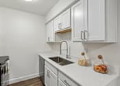 Thumbnail 20 of 46 - A kitchen with white cabinets and a black oven.