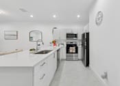 Thumbnail 4 of 20 - bright open kitchen with island and modern finishes in 3 bedroom home for rent Pompano Beach FL