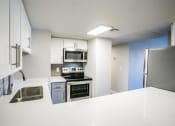 Thumbnail 26 of 31 - a kitchen with a stove a sink and a refrigerator