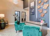 Thumbnail 12 of 19 - Sky Harbor Apartments in Chamblee, GA photo of a a living room with blue chairs and a desk and a wall with seashells