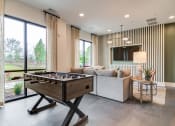Thumbnail 4 of 19 - Sky Harbor Apartments in Chamblee, GA photo of a a games room with a foosball table and a couch