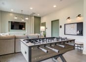 Thumbnail 3 of 19 - Sky Harbor Apartments in Chamblee, GA photo of a a foosball table in a living room with a couch