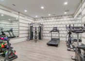 Thumbnail 6 of 19 - Sky Harbor Apartments in Chamblee, GA photo of a a gym with treadmills and other exercise equipment in a room with white walls