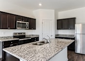 Thumbnail 28 of 75 - A kitchen with granite countertops and stainless steel appliances.