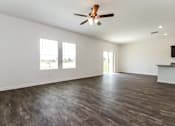 Thumbnail 29 of 75 - A room with a ceiling fan and wooden flooring.