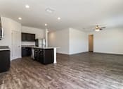 Thumbnail 23 of 75 - A spacious room with a kitchen area and a ceiling fan.