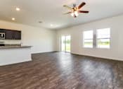 Thumbnail 24 of 75 - A spacious room with a ceiling fan and wooden flooring.