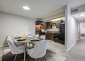Thumbnail 1 of 15 - Somerset Apartments in Charlotte, NC photo of a dining area with a table and chairs and a kitchen in the background