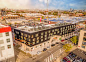 Thumbnail 29 of 29 - A large building with a parking lot in front of it.